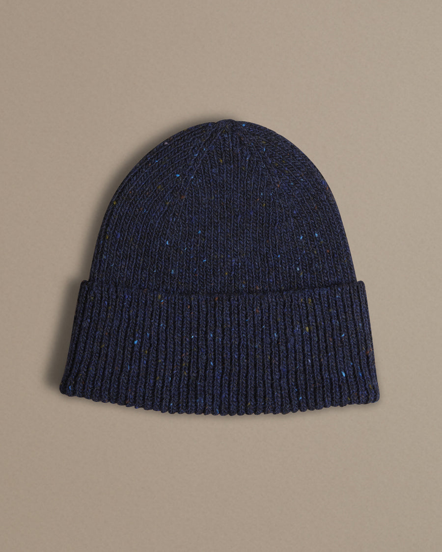 Dark blue knit beanie on a beige background